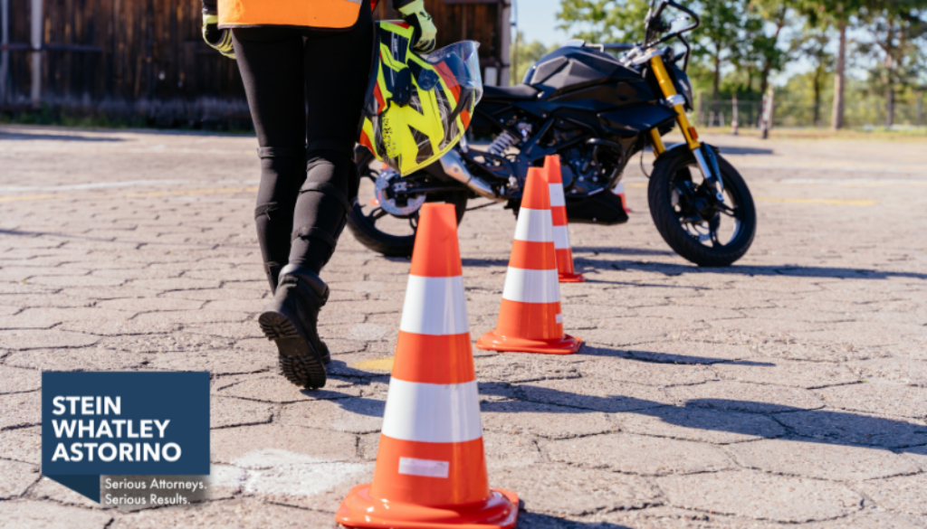 Orange cones and motorcycle with instructor walking.