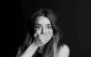 Picture of woman covering her mouth with her hand after she realized Should I Talk to the Insurance Company After an Accident